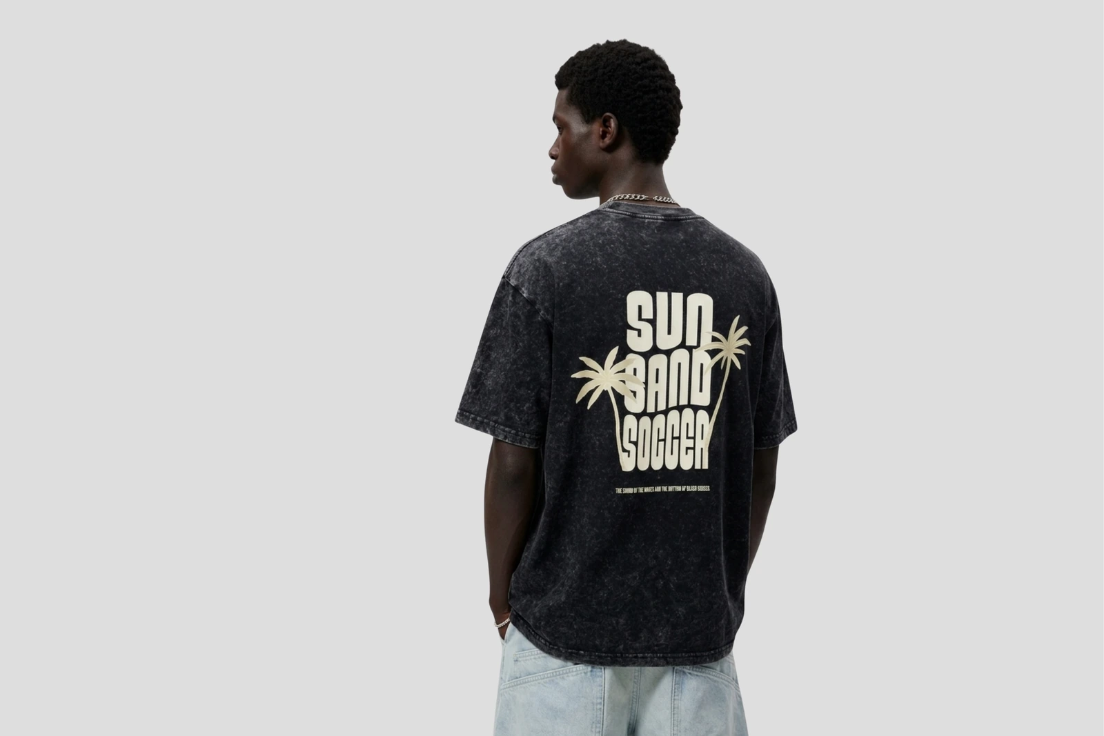 Studio portrait wearing the oversized black ONLY SAND graphic T-shirt and light blue jeans
